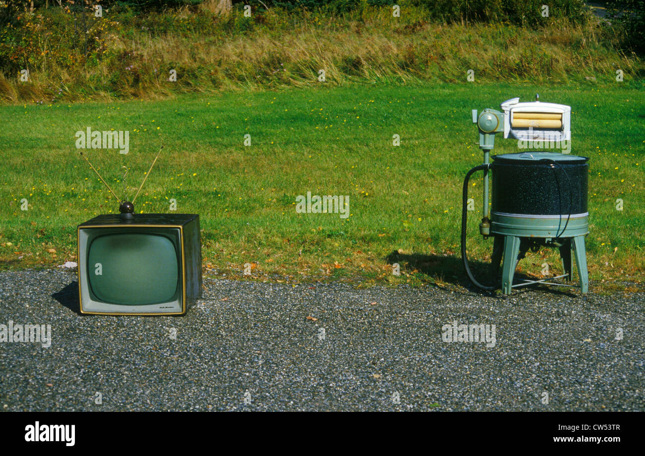 Old retro television set with rabbit ears antennae with old fashioned washing machine, New England Stock Photo