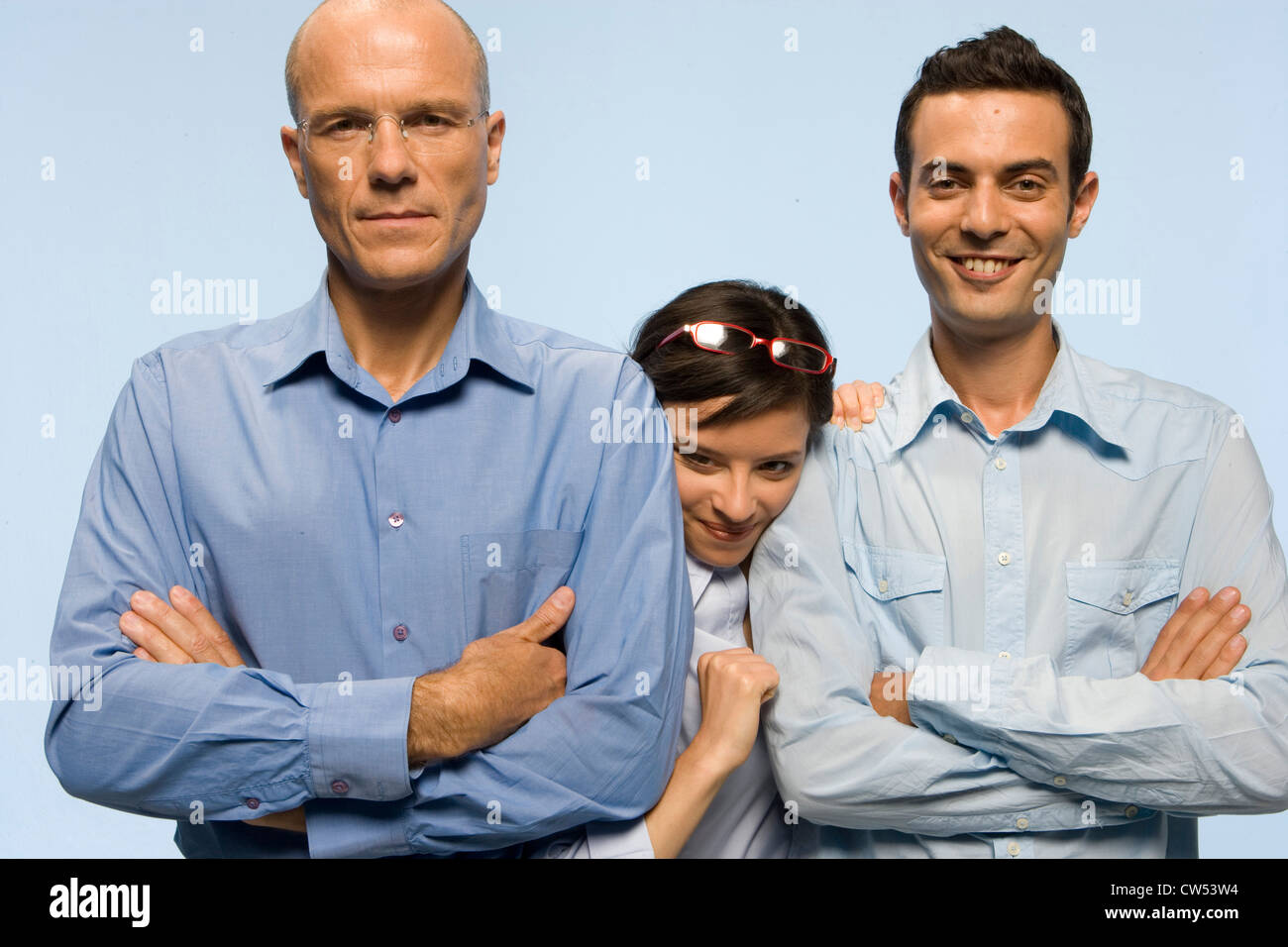 Businesswoman pushing her way in between two businessmen Stock Photo
