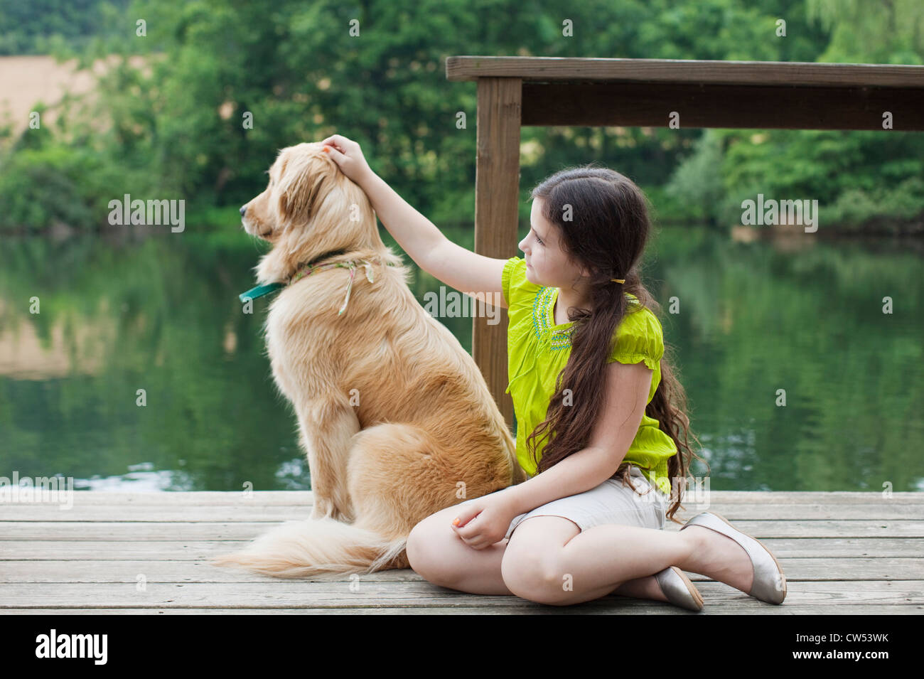 Girl with Golden Retriever on jetty Stock Photo - Alamy