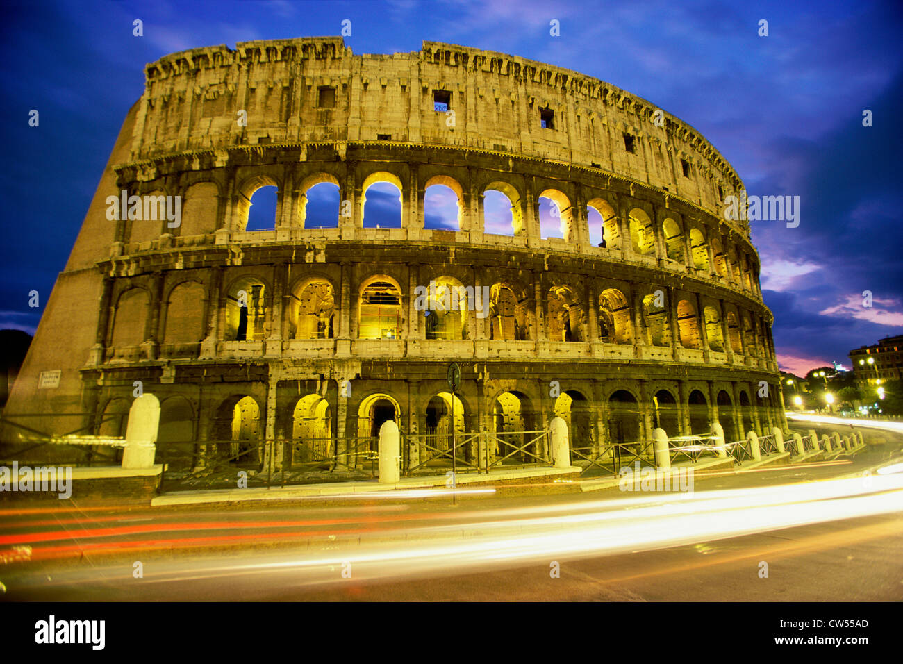 Low angle view of the old ruins of an amphitheater lit up at dusk, Colosseum, Rome, Italy Stock Photo