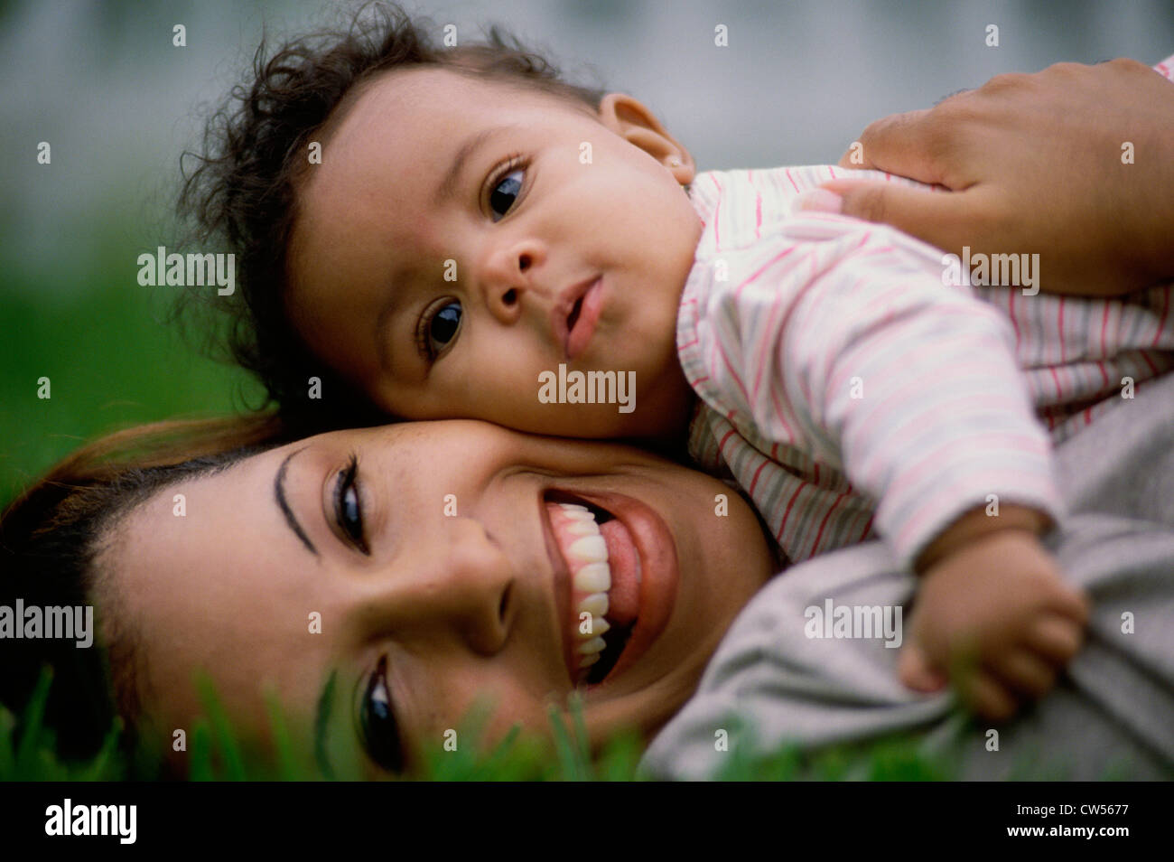 Portrait of a mid adult woman lying on grass with her son Stock Photo ...