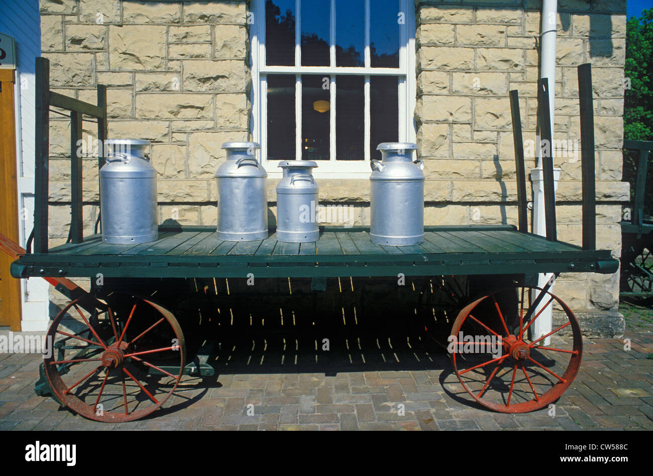 An old standard gauge steam engine car holds antique milk cans in Eureka Springs, Arkansas Stock Photo