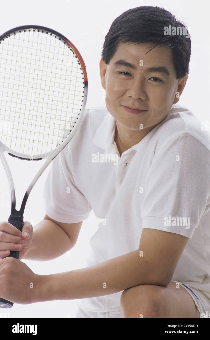 Portrait of a man holding a tennis racket Stock Photo
