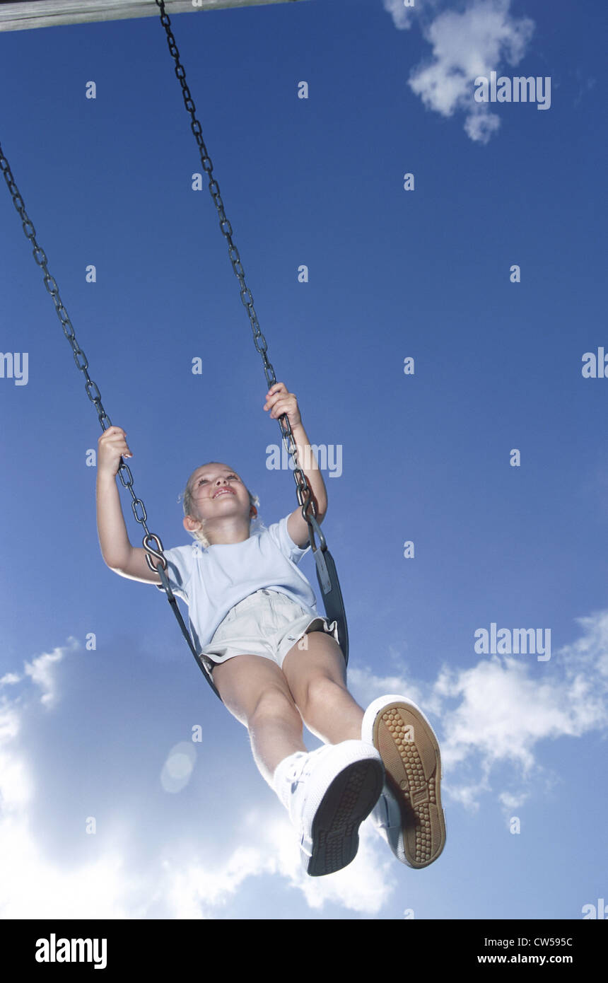 Low angle view of a girl swinging on a swing Stock Photo