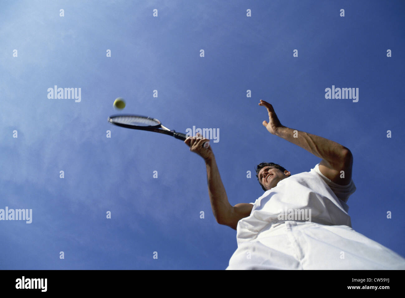 Low angle view of a mid adult man playing tennis Stock Photo