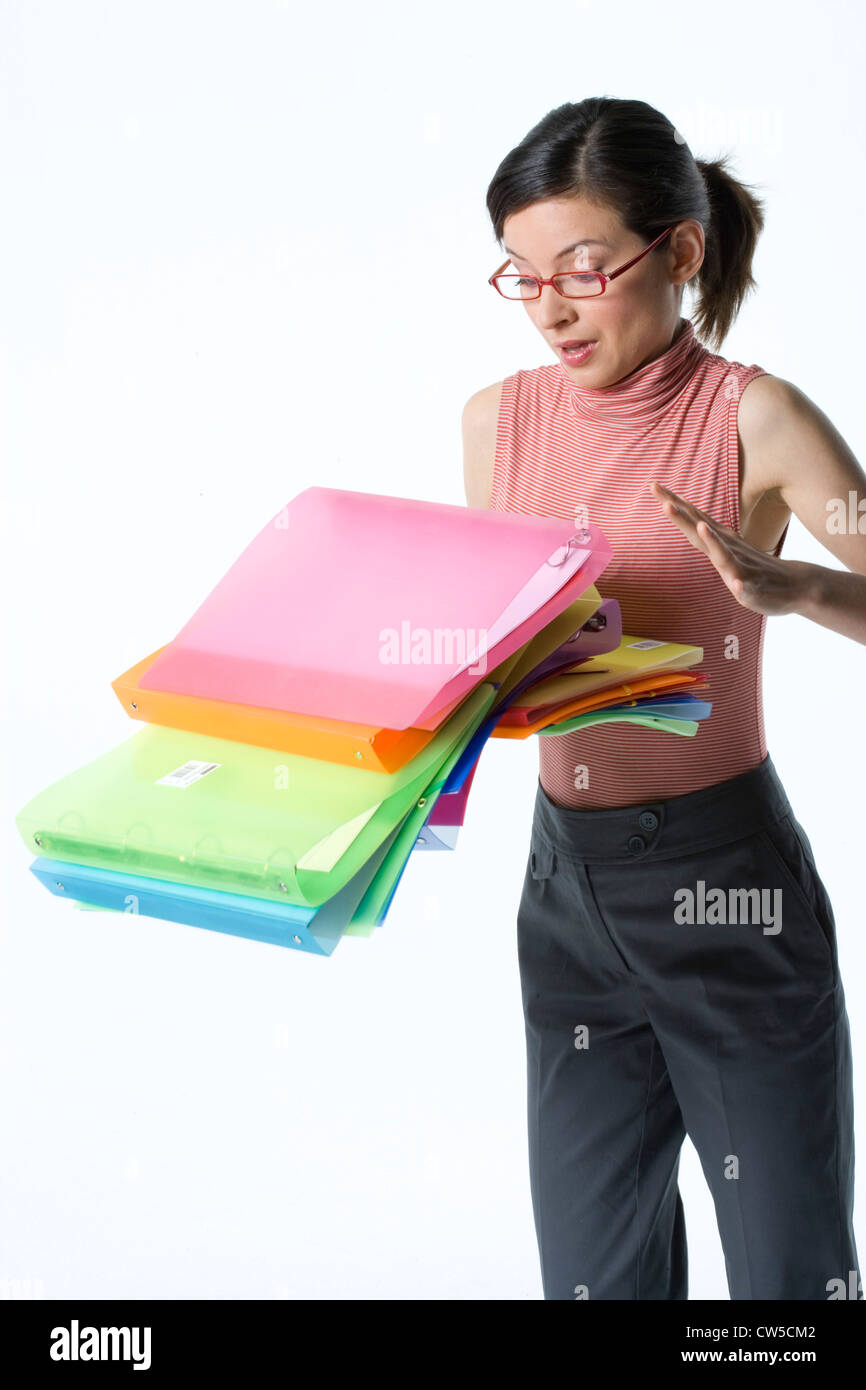 Stack of ring binders falling from a businesswoman's hands Stock Photo