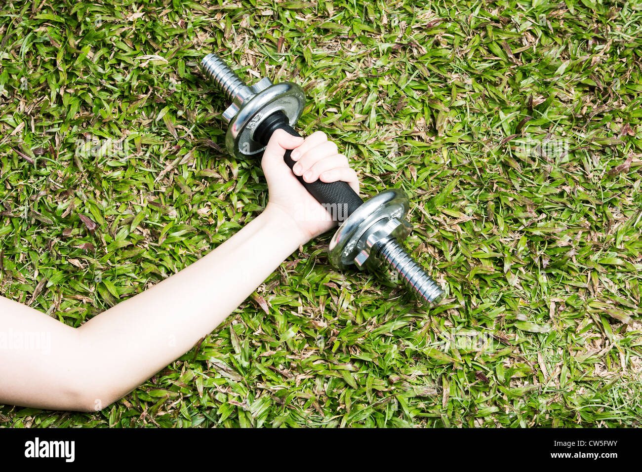 Asian woman exercising with dumb bell weights outside. Stock Photo