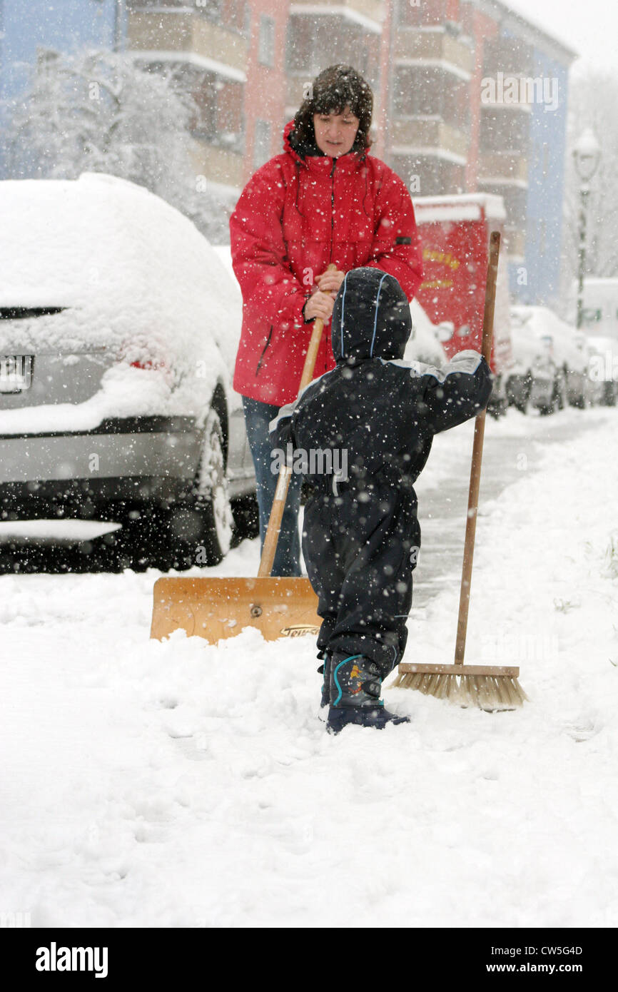 Berlin, mother and child during snow shoveling Stock Photo