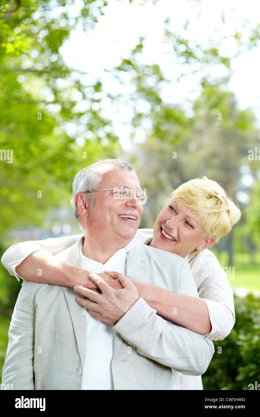 Portrait of happy mature woman hugging her husband outside Stock Photo