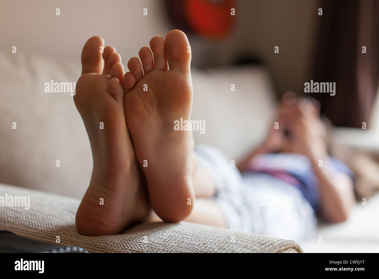 Young girl plays on mobile phone at home Stock Photo