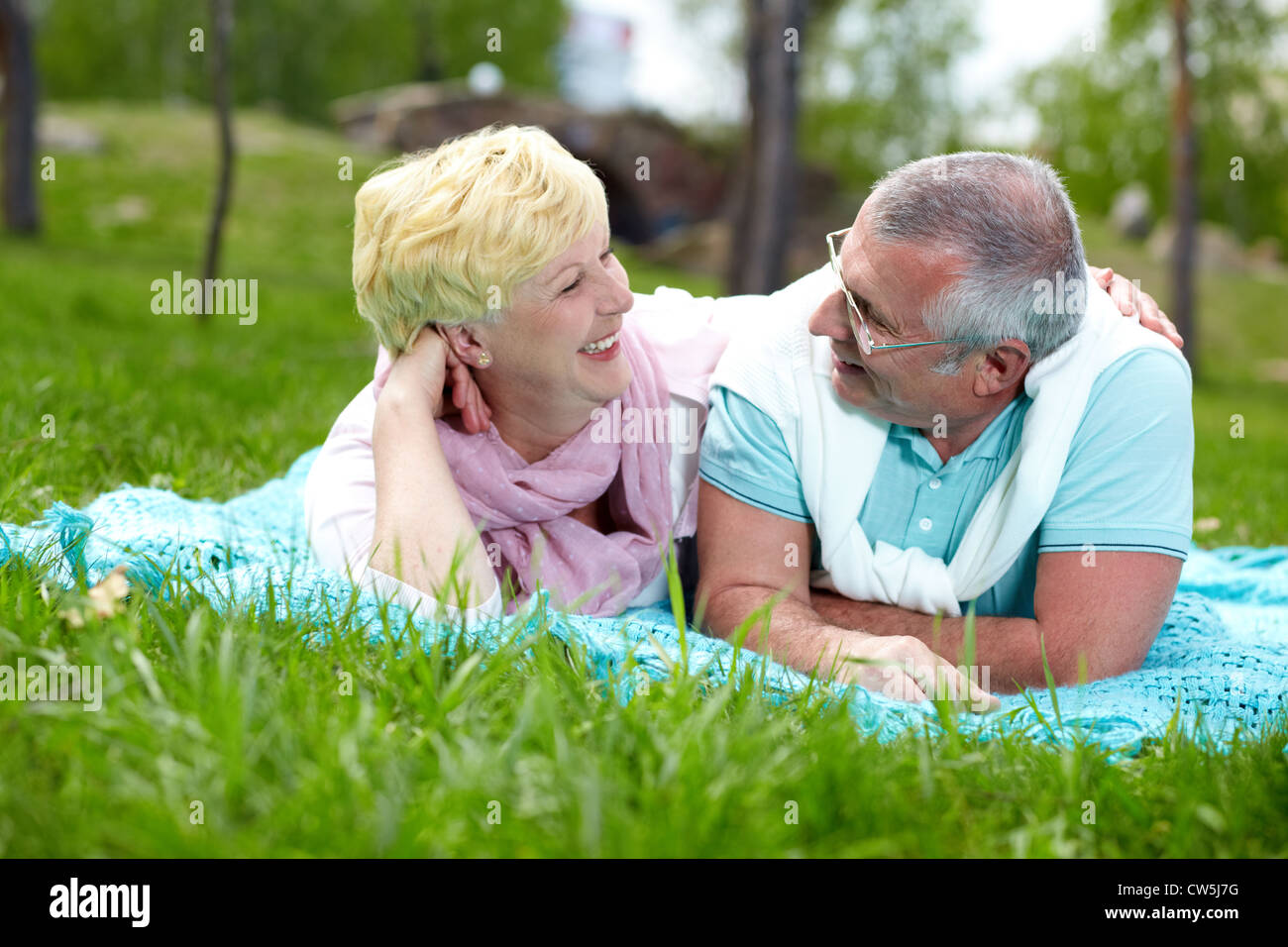 Happy mature couple lying on grass and talking in the countryside Stock ...