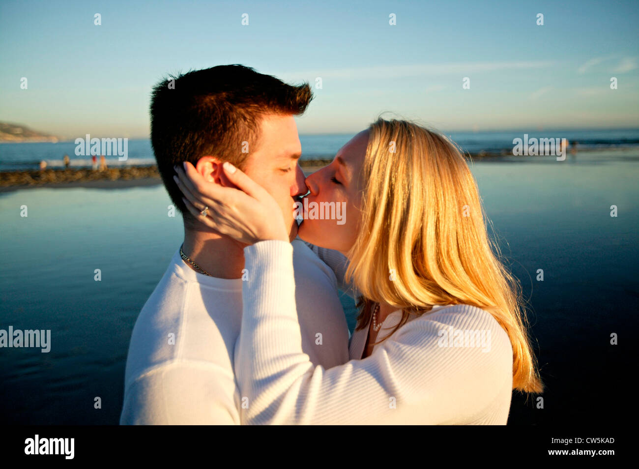 Side profile of a young couple kissing Stock Photo - Alamy