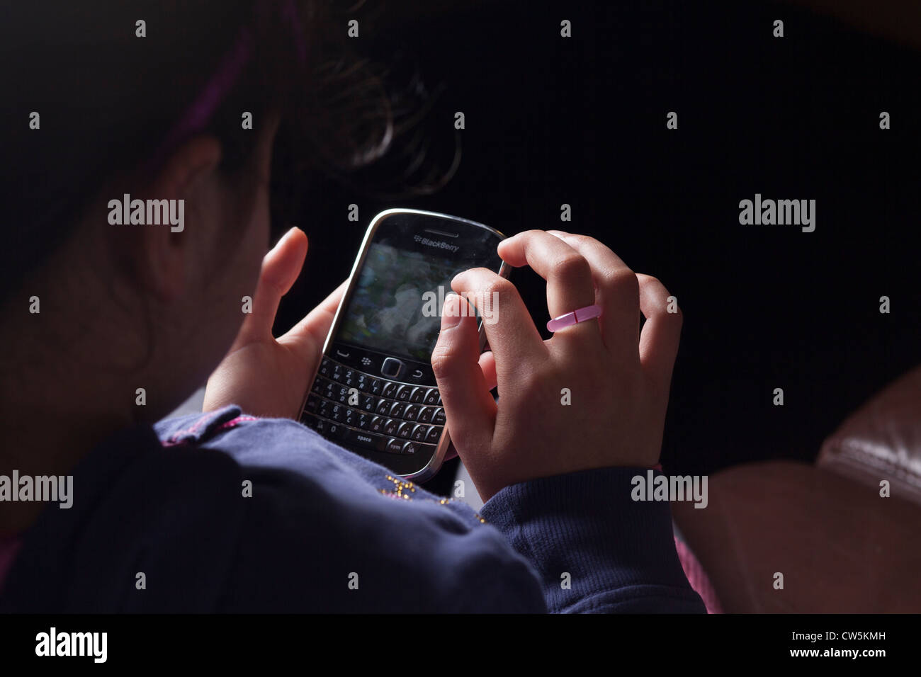 Child texts on  a Blackberry Smart Phone Stock Photo