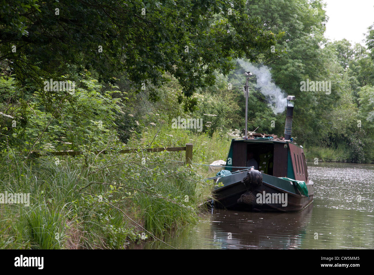 Smoking chimney of a narrow boat moored in Ashby canal. Stock Photo