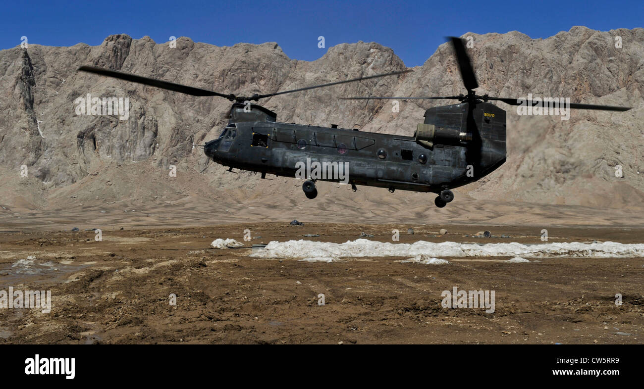 A CH-47 Chinook helicopter approaches a remote landing zone to drop off supplies in Shah Joy district, Zabul province, Afghanistan, March 10. Helicopters provide coalition special operations forces an efficient and reliable means of transporting personnel and cargo in rural areas of Afghanistan. Stock Photo