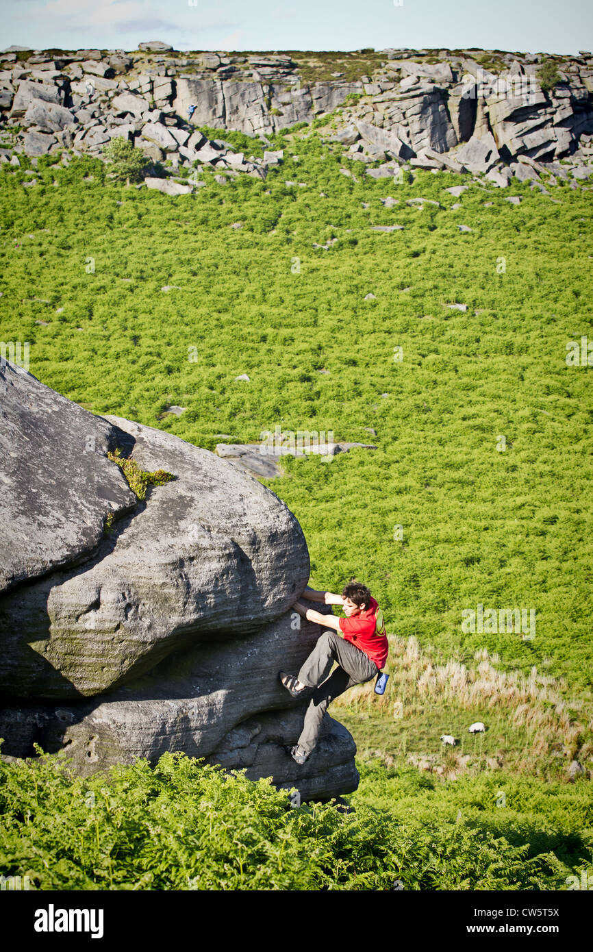 Tom Randall rock climbs a crack at Burbage in Sheffield near Stanage on the Peak District National Park Derbyshire, England Stock Photo