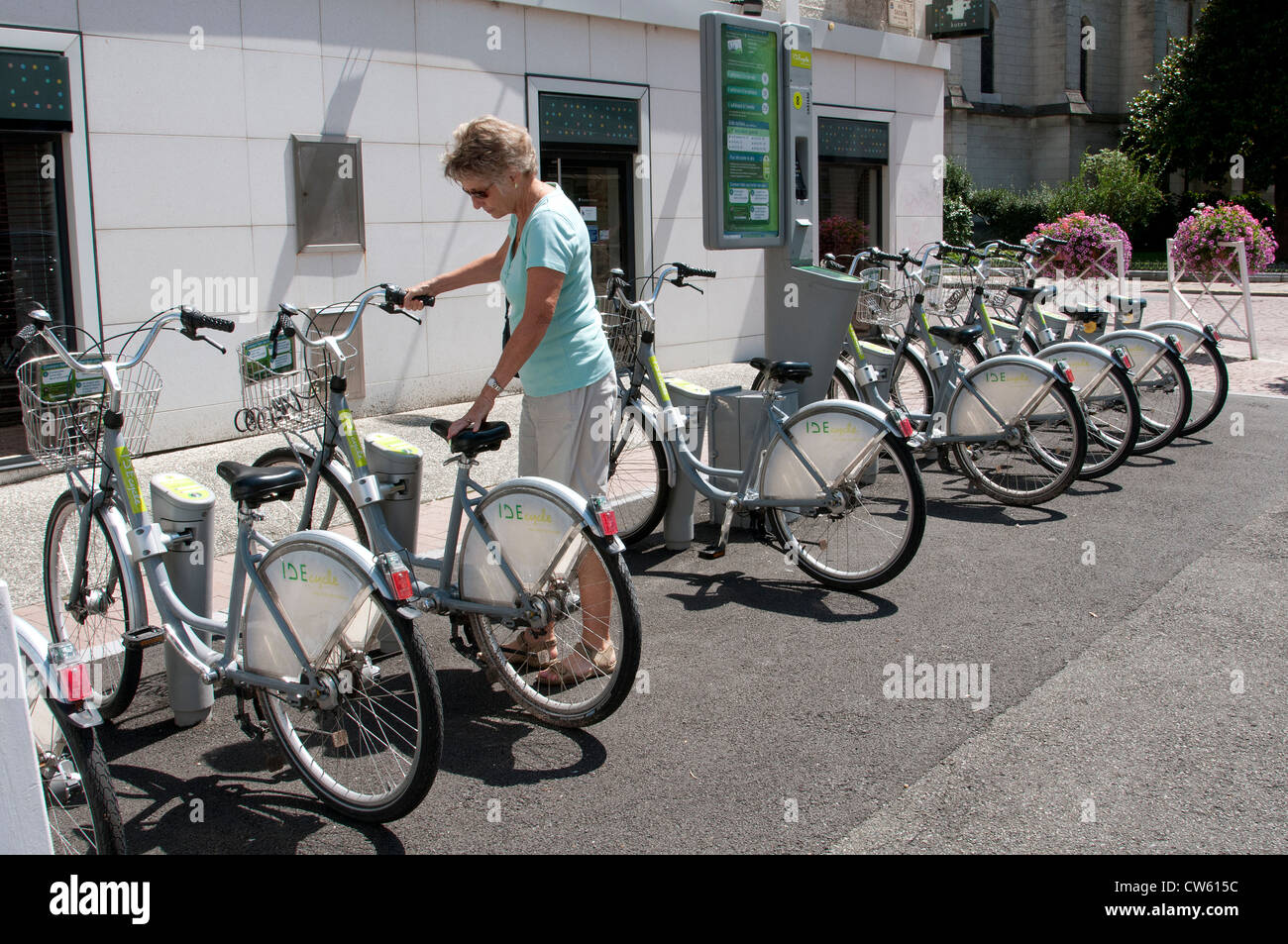 IDE cycle system in Pau city centre southwest France Woman collecting a bicycle to tour the city Stock Photo