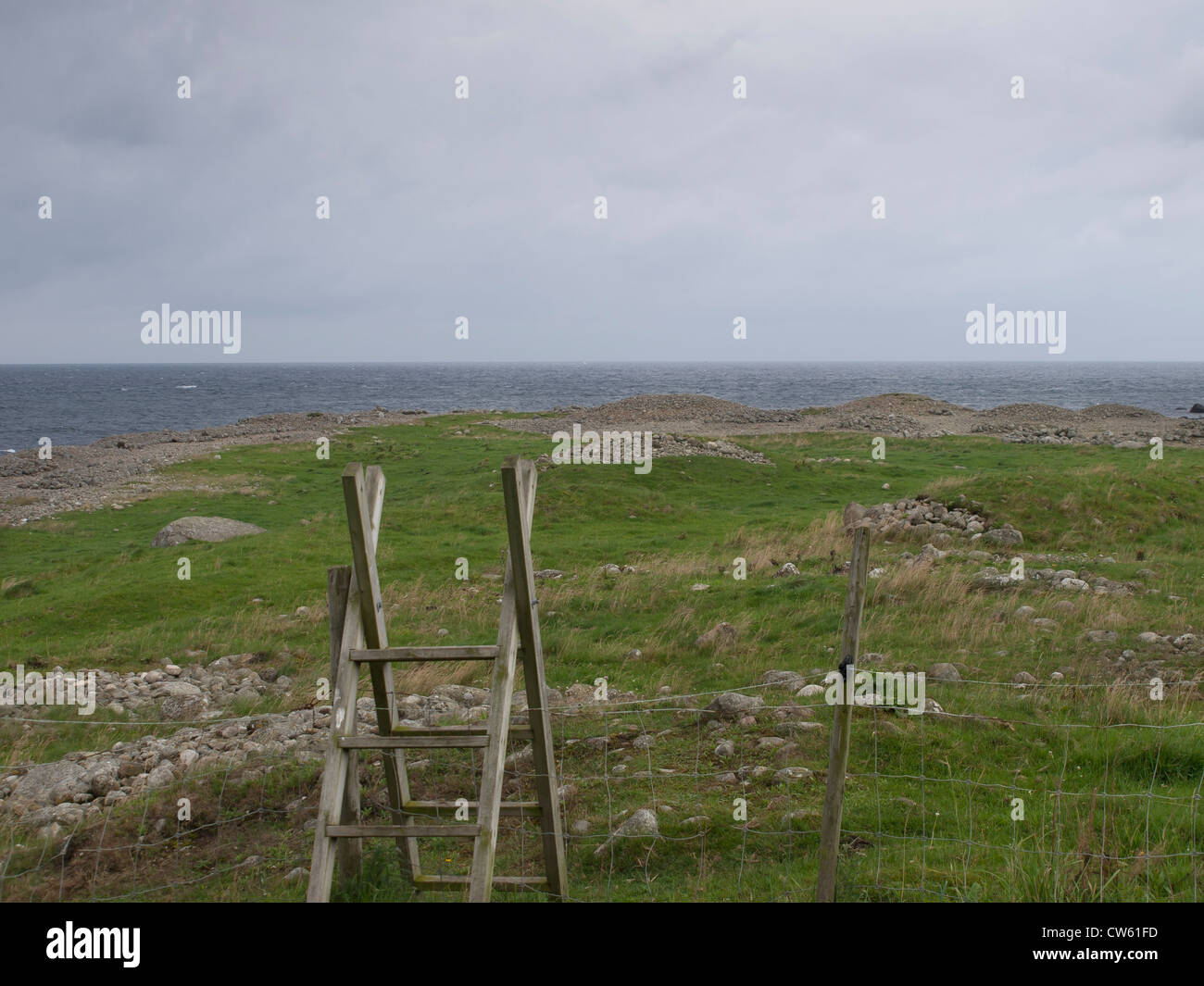 Ladder set up to help walkers cross a wire fence. Jaeren outside of Stavanger Norway has many footpaths along the coast . Stock Photo