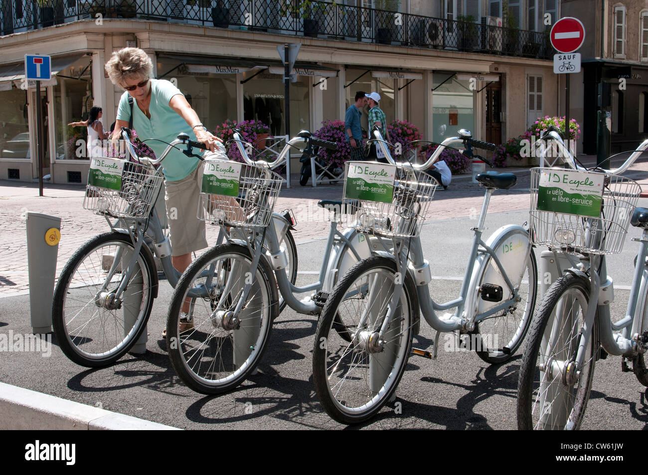 IDE cycle system in Pau city centre southwest France Woman collecting a bicycle to tour the city Stock Photo