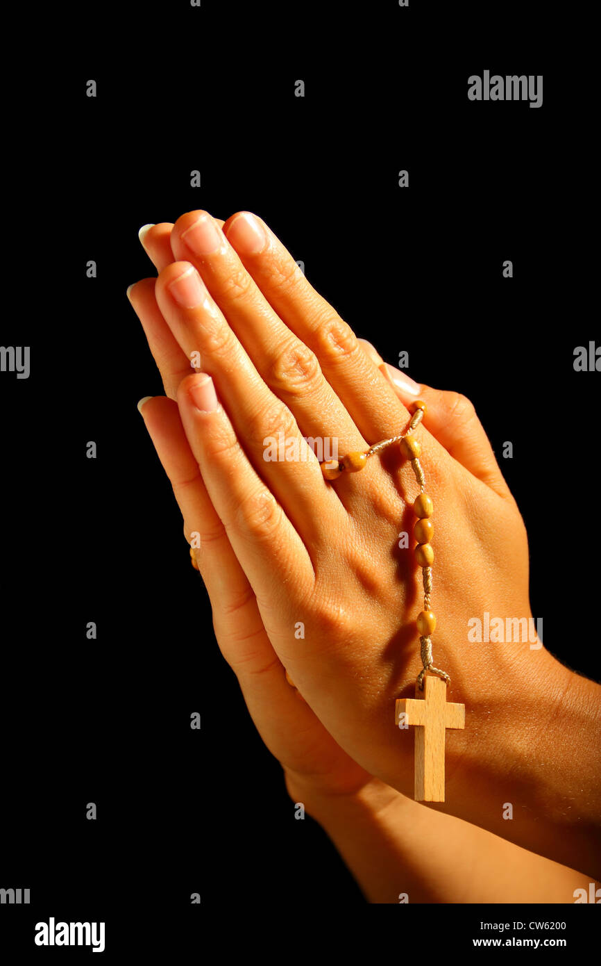 Christian human praying with rosary in hands Stock Photo