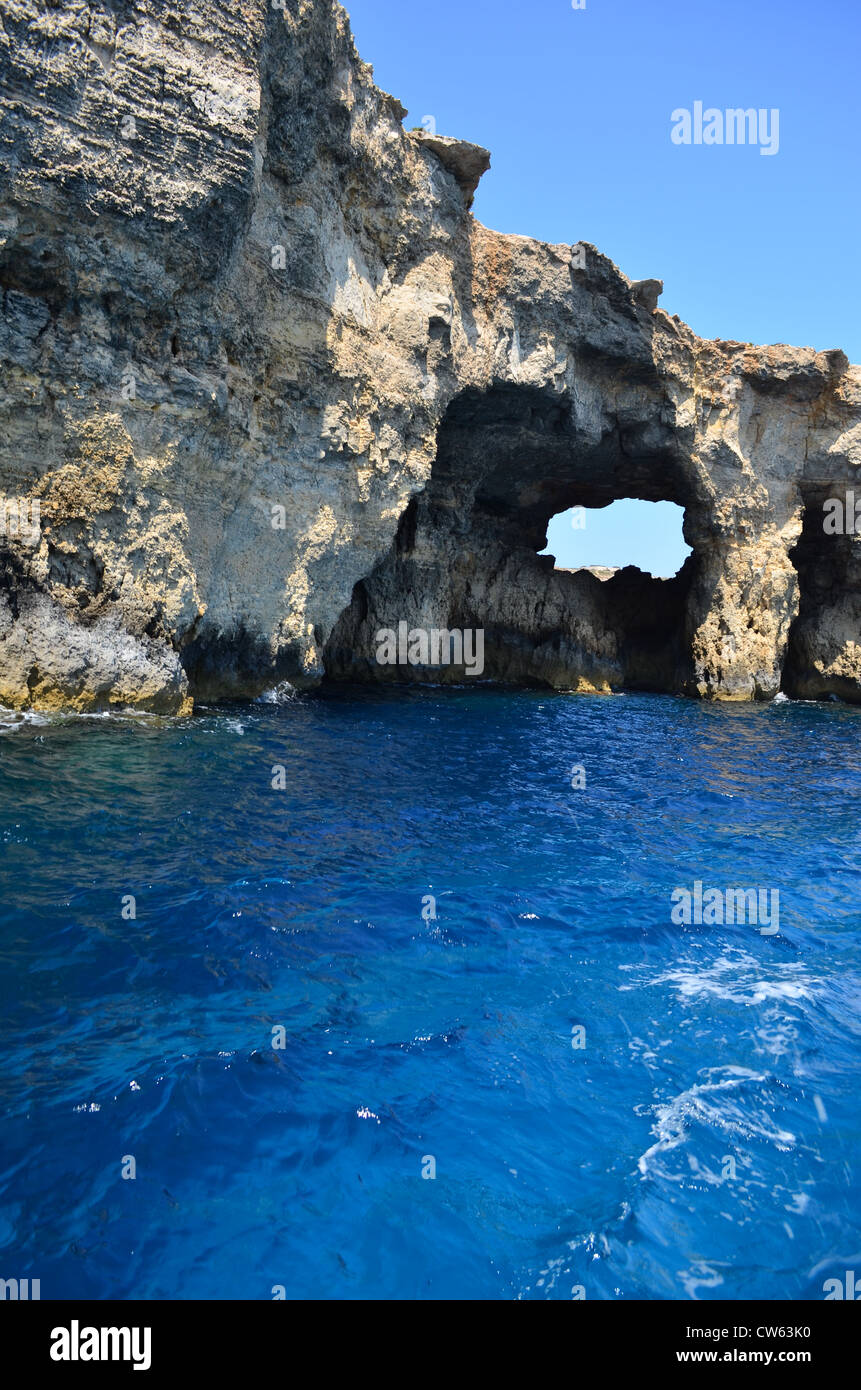 Caves and deep blue waters surrounding the island of Comino - Malta Stock Photo
