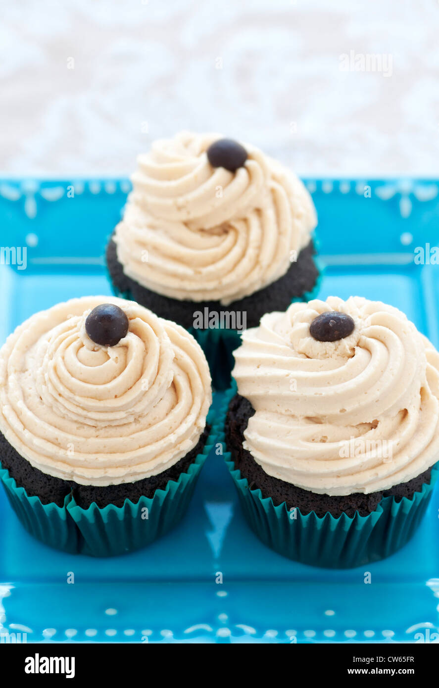 Chocolate Cupcakes with coffee buttercream and chocolate espresso bean on turquoise plate Stock Photo