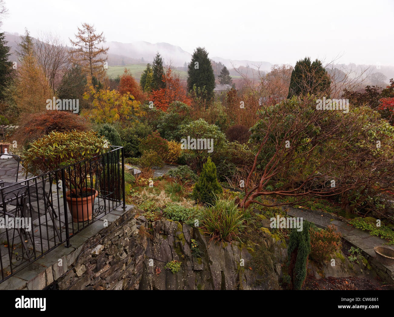 Rock garden with Autumn colour in morning mist, Elterwater, Cumbria, England, UK Stock Photo