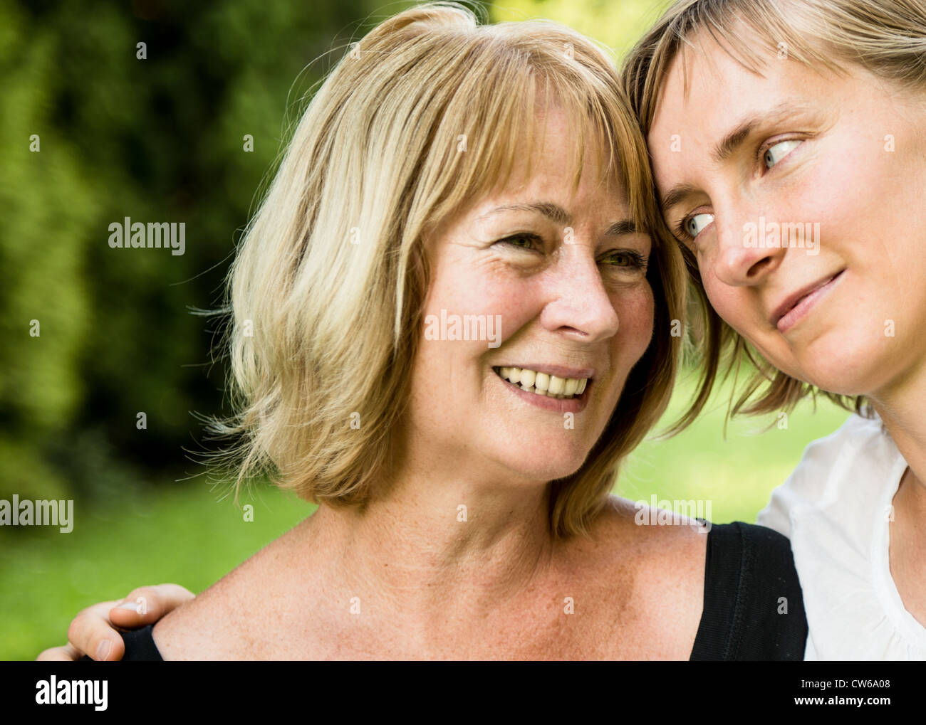 Outdoor portrait of smiling happy senior mother with her adult daughter Stock Photo
