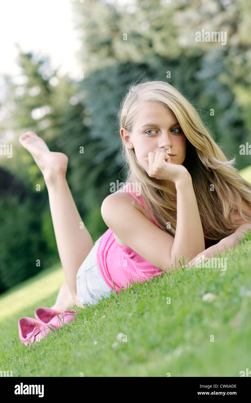 young blond girl lying on a meadow Stock Photo