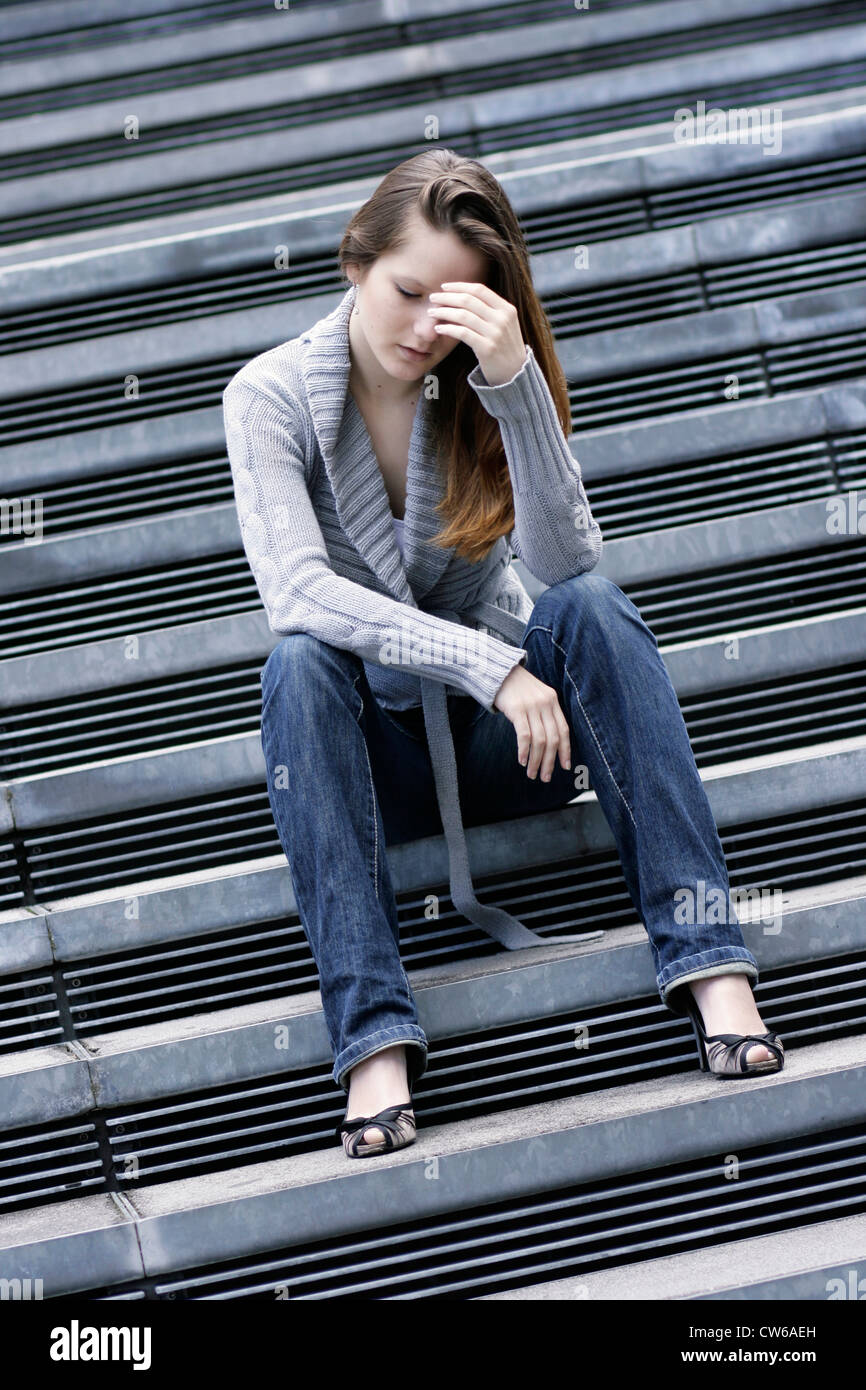 young cute woman sitting on stairs Stock Photo