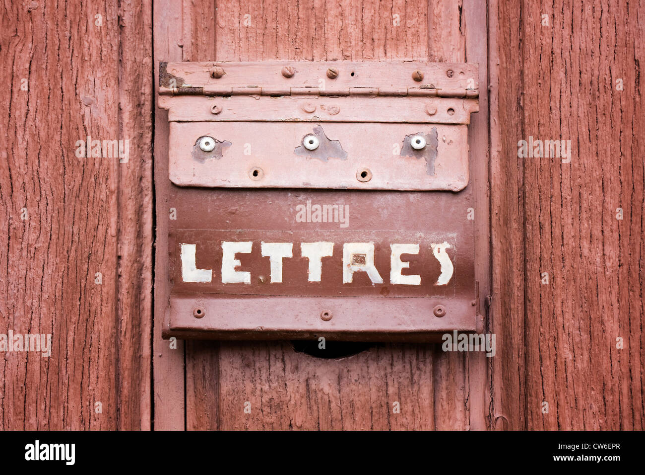 A letterbox in a wooden door, France. Stock Photo