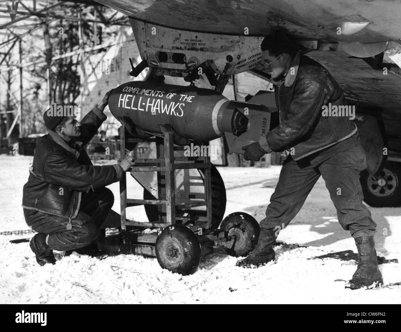 Armored of a fighter bomber group adjust a bomb under a P-47 fighter bomber (February 7, 1945) Stock Photo