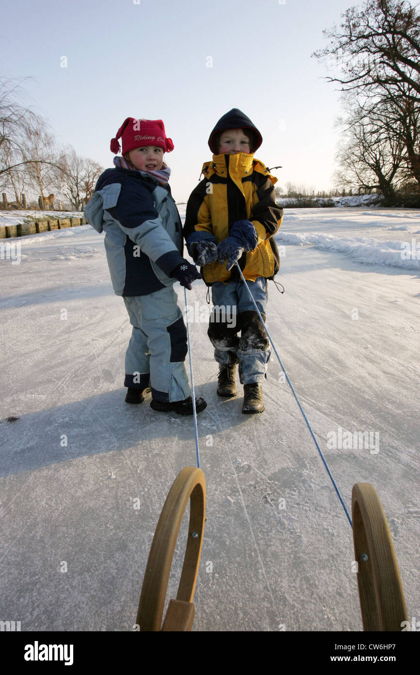 Resplendent village, children pull a sled Stock Photo
