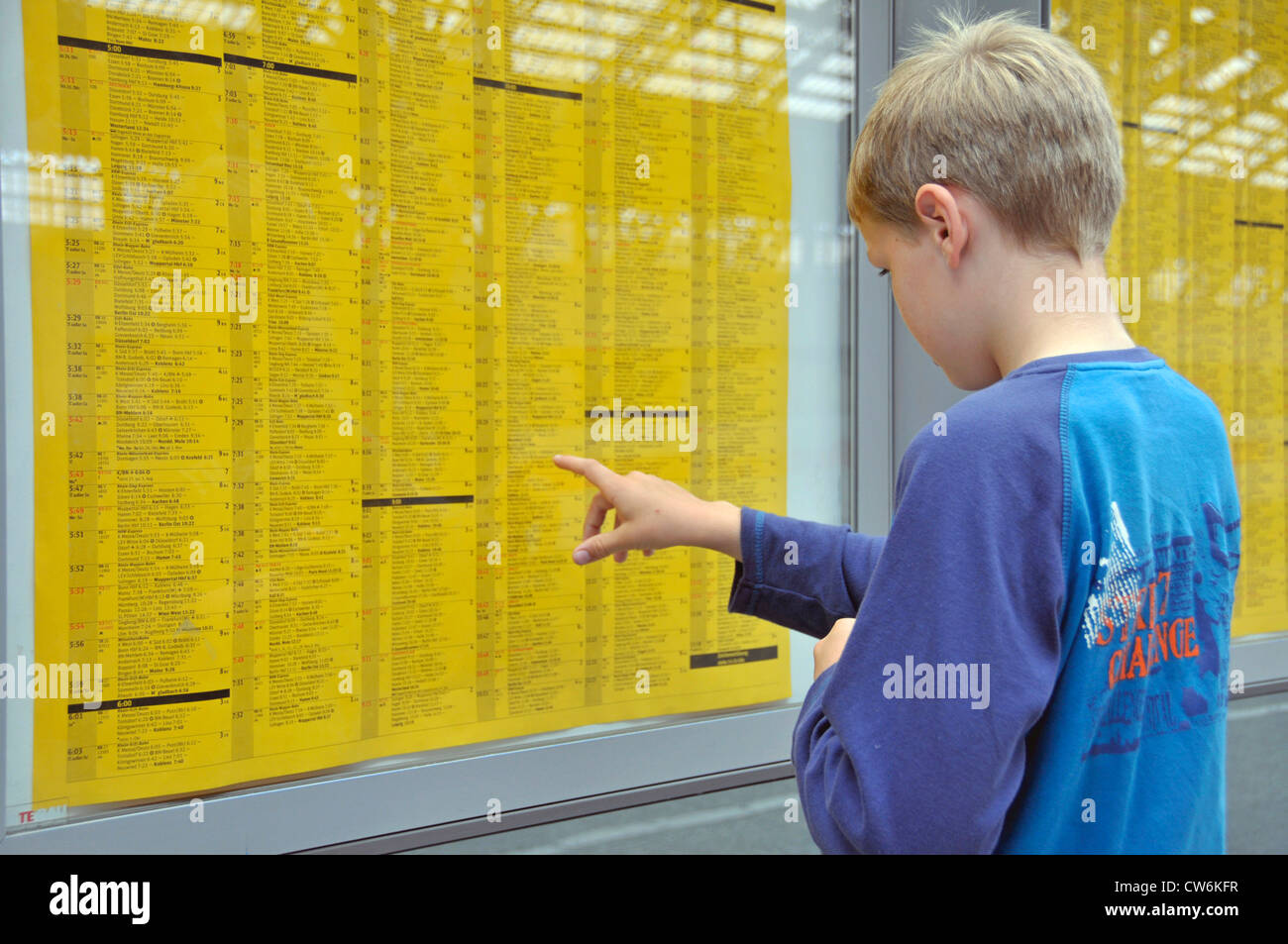 9 years old boy looking at the timetable of Deutsche Bahn, Germany, North Rhine-Westphalia, Cologne Stock Photo
