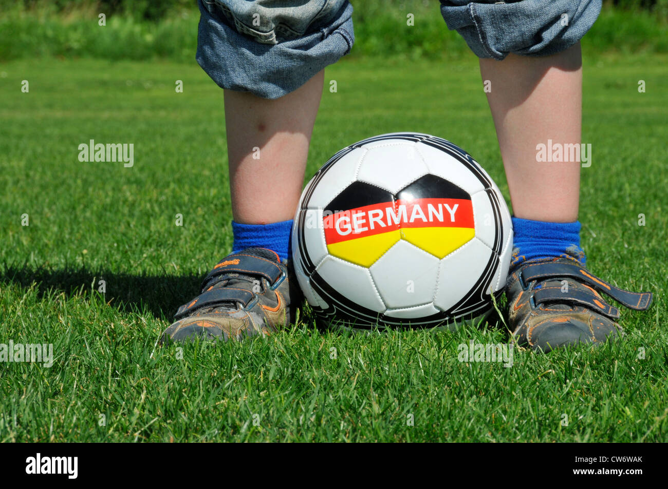 boy standing on a lawn with a football between the feet with the writing 'Germany', Germany, Baden-Wuerttemberg Stock Photo