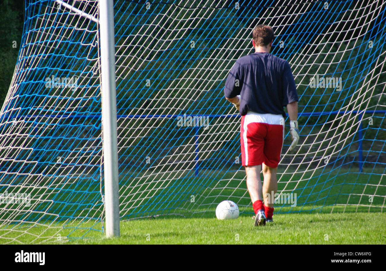 goal keeper taking the football out of the football goal Stock Photo