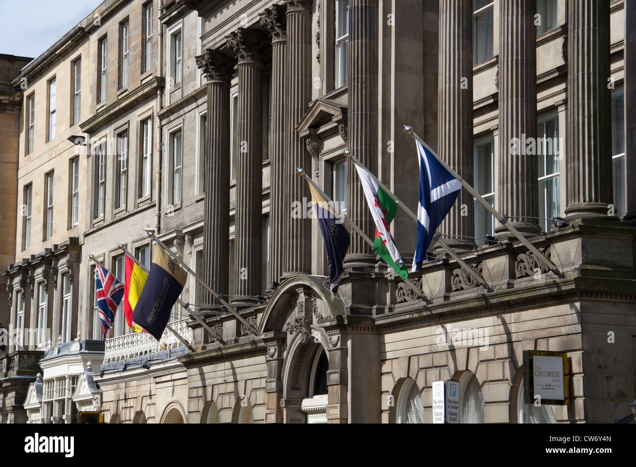 A hotel building in Edinburgh in Scotland, with flags in front. These buildings all have the same kind of architecture Stock Photo