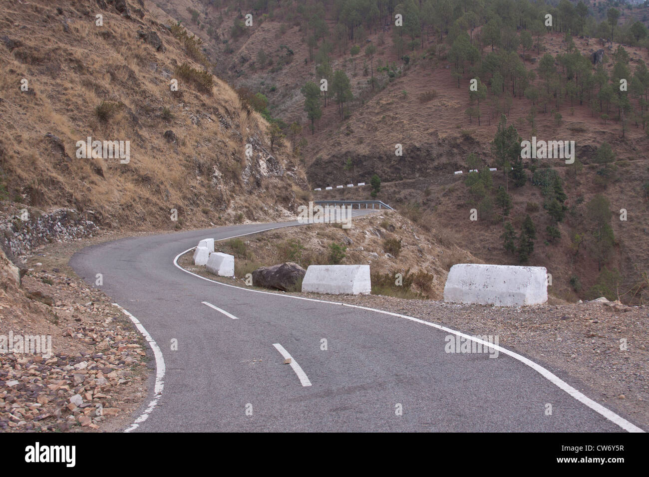 A road in the Himalayas in North India, with the road being wide enough for 2 vehicles to pass each other with a steep fall Stock Photo