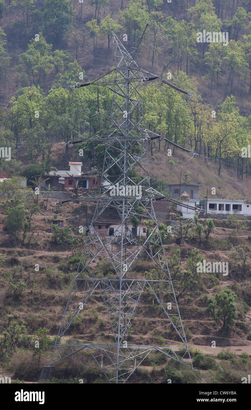 Building and power transmission tower in Uttarakhand, with the stepped farming on the slope behind along with some houses Stock Photo