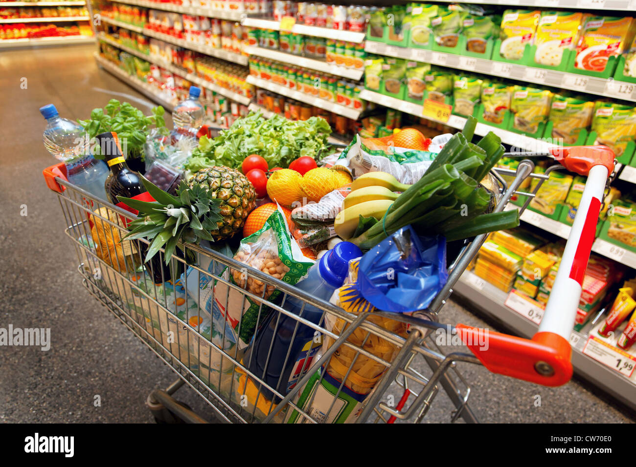 Full shopping cart with fruits, vegetables, food in supermarket Stock Photo