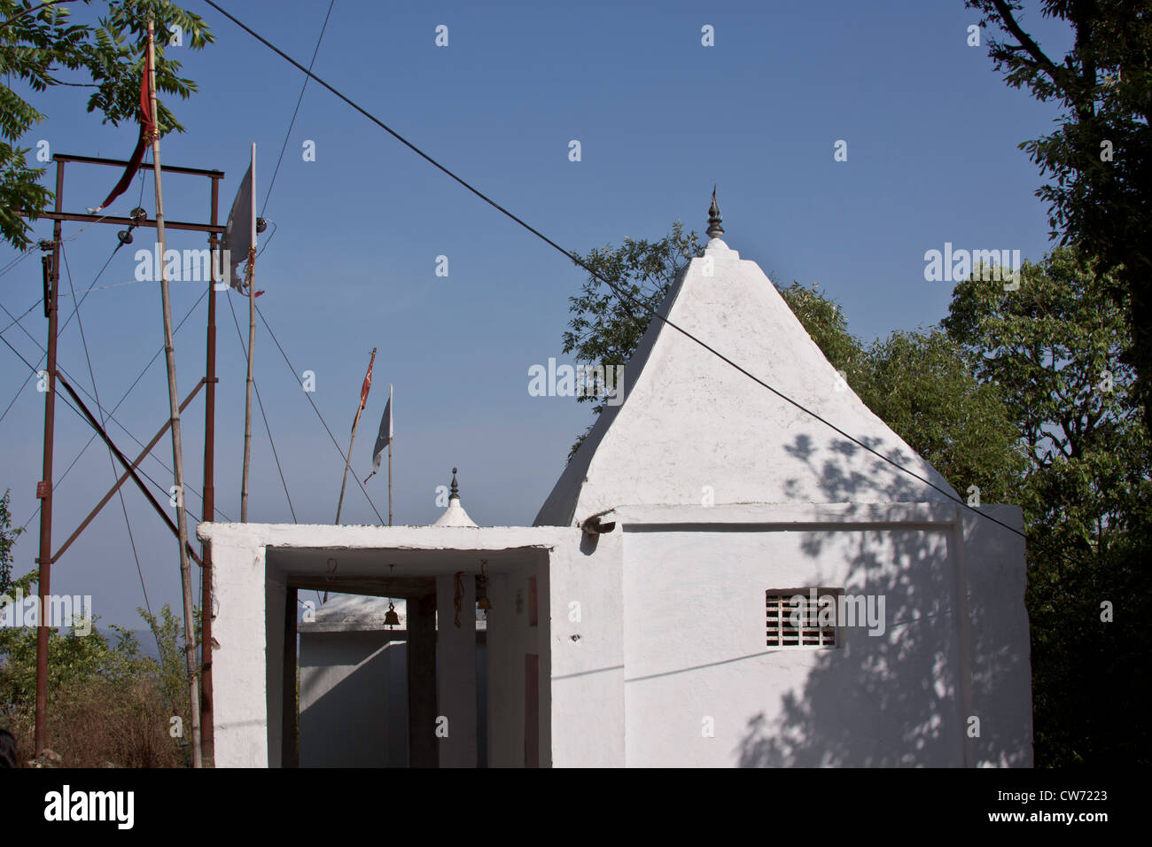 White temple building near Lansdowne in North India, located on the slope of a mountain and with electric pole nearby. Stock Photo
