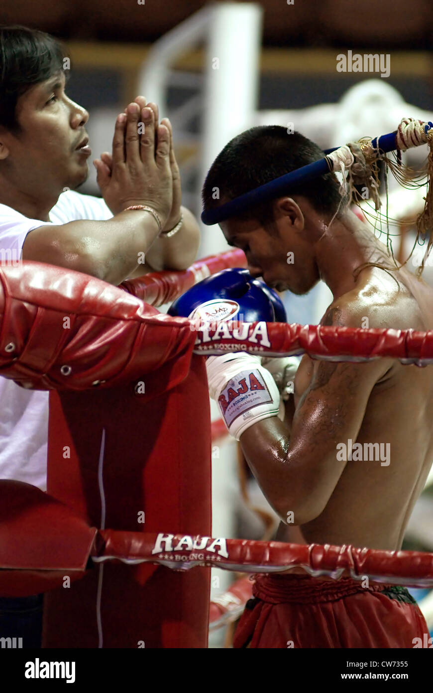young Muay Thai Boxer and his trainer praying and performing a ritual before a fight, Thailand, Krabi Stock Photo