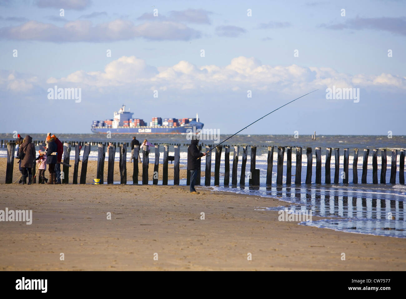 angler at the beach of Breskens, container ship on Westerschelde in the background, Germany, Zeeland, Breskens Stock Photo