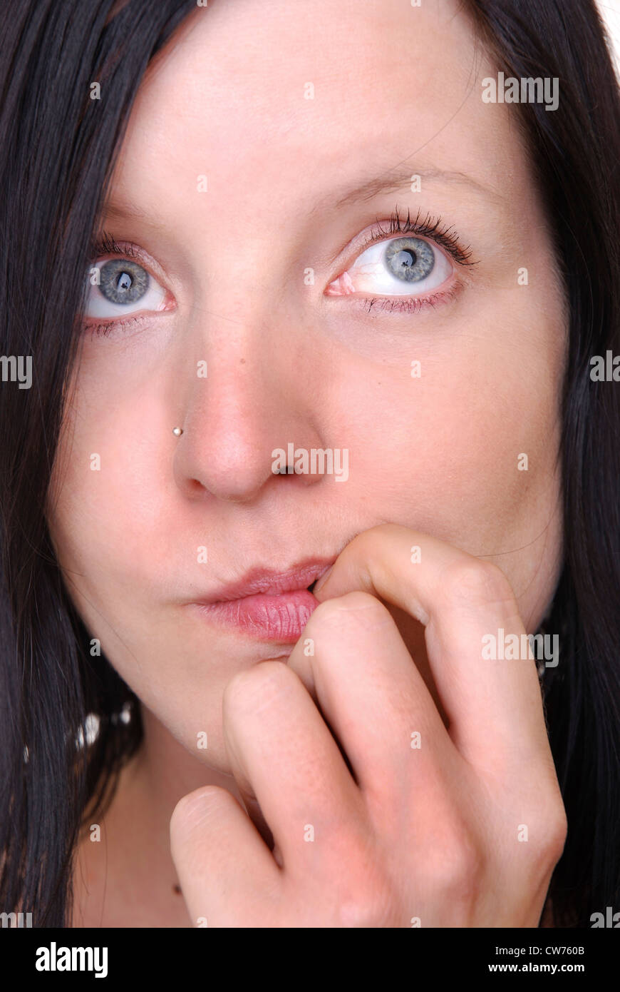 Woman chews at her finger Stock Photo
