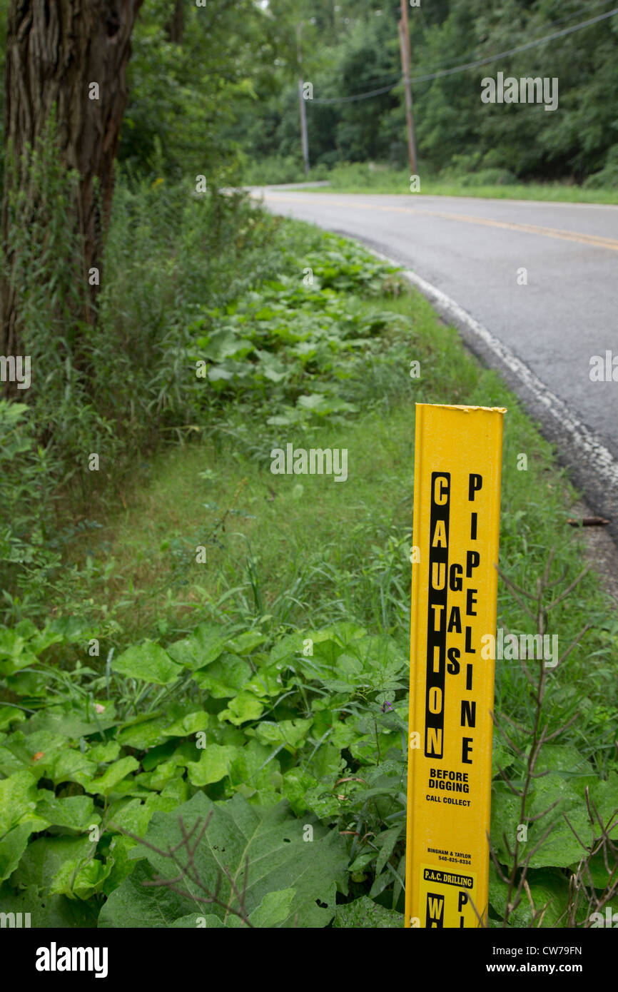 A marker warns of a buried gas pipeline along a road north of