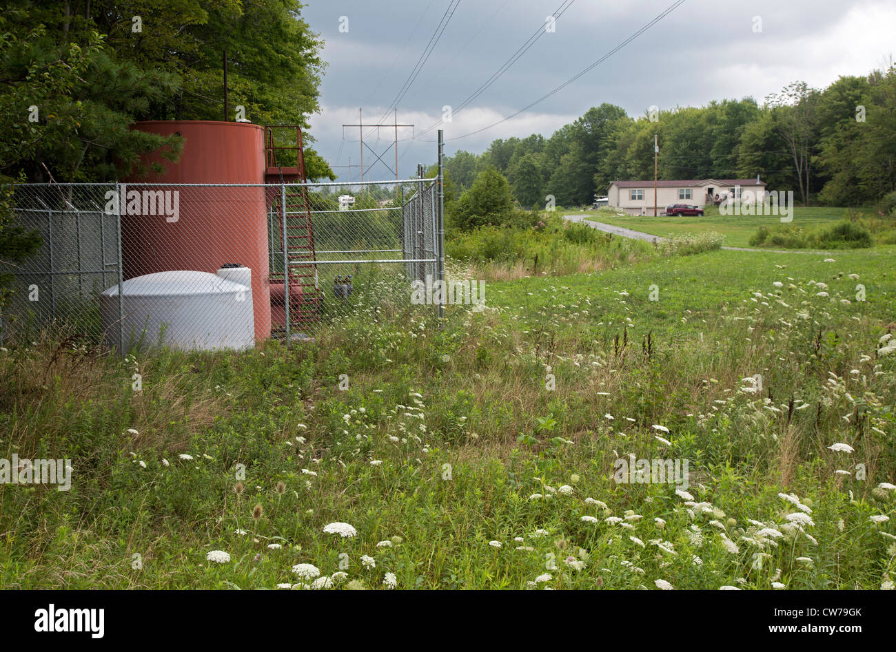 A natural gas tank and compressor near a home in the countryside north