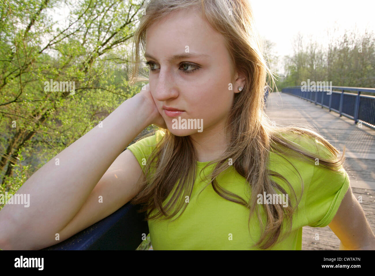 teenage girl standing on bridge, lost in thought, Germany, Ruhr Area Stock Photo