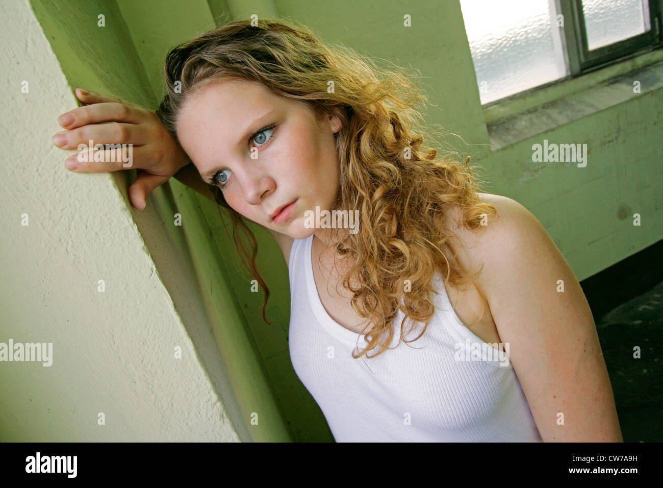 young woman leaning against wall, Germany Stock Photo