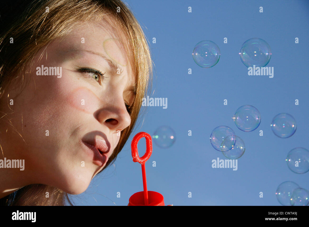 young woman blowing bubbles Stock Photo