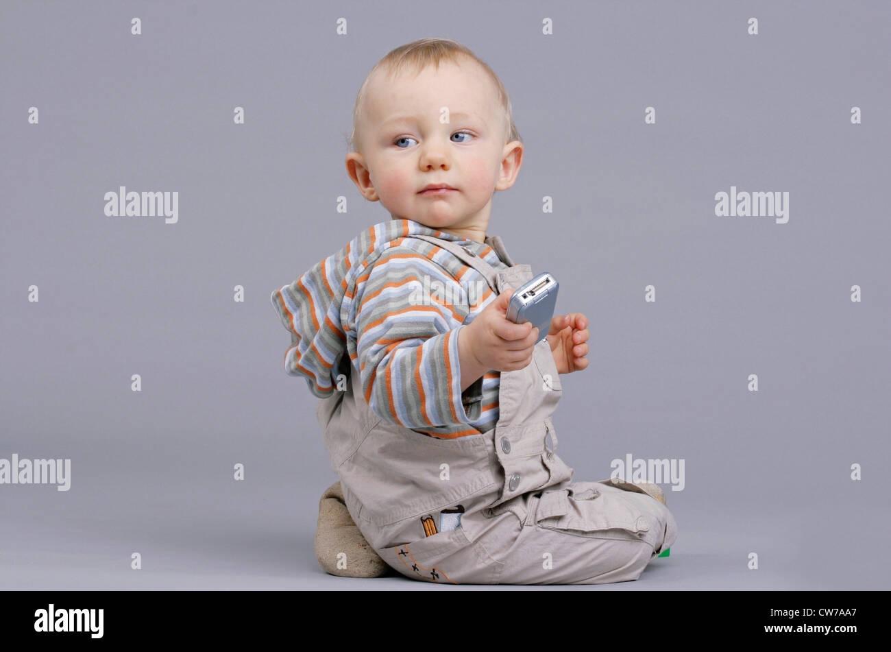 little boy holding mobile in hand, Germany Stock Photo